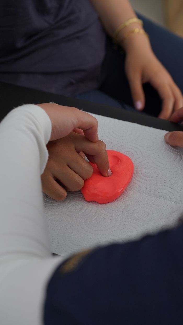 Crafting Captivating Headlines: Your awesome post title goes here Close-up of hands manipulating putty during therapy session, emphasizing motor skills.