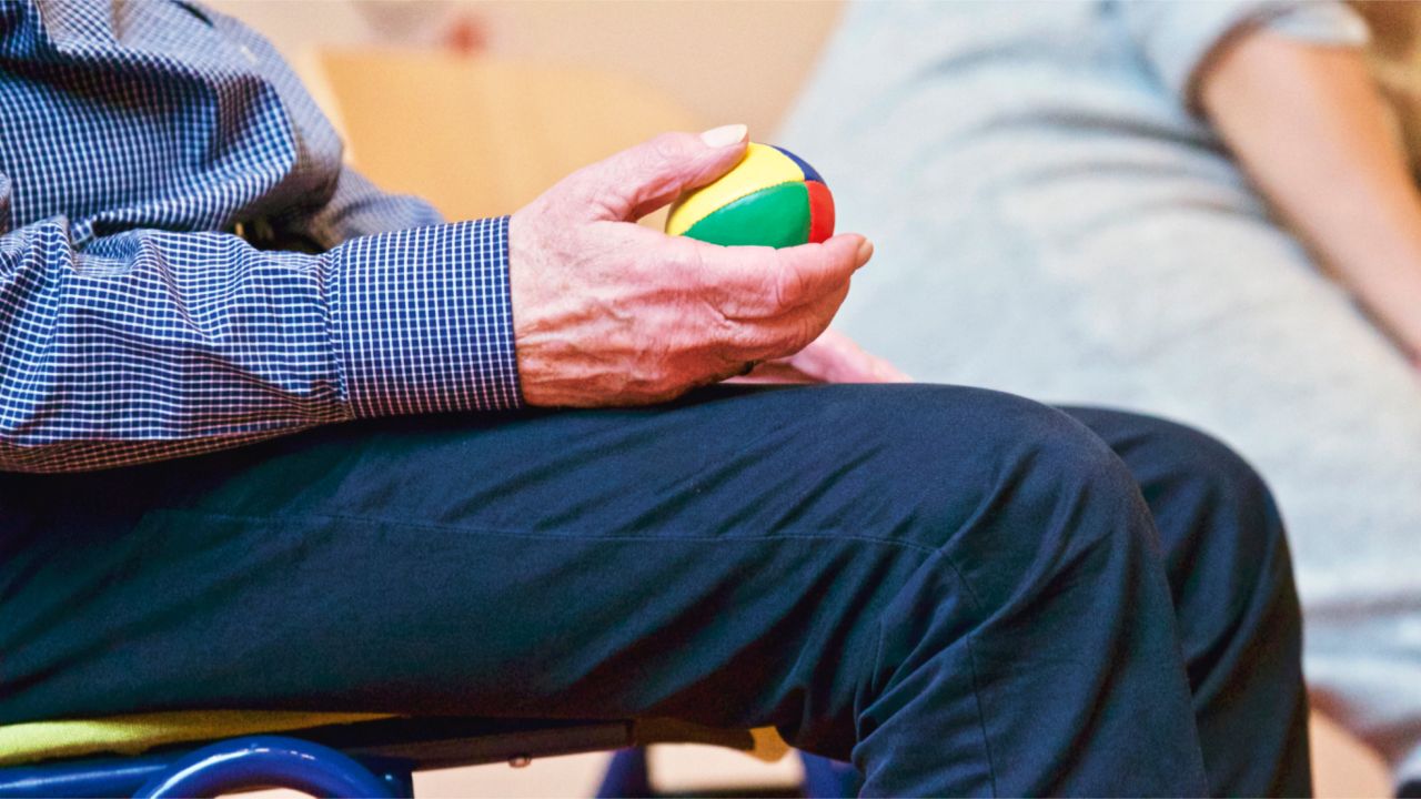 The Art of Drawing Readers In: Your attractive post title goes here Elderly man holding a colorful therapy ball indoors, promoting relaxation and health.